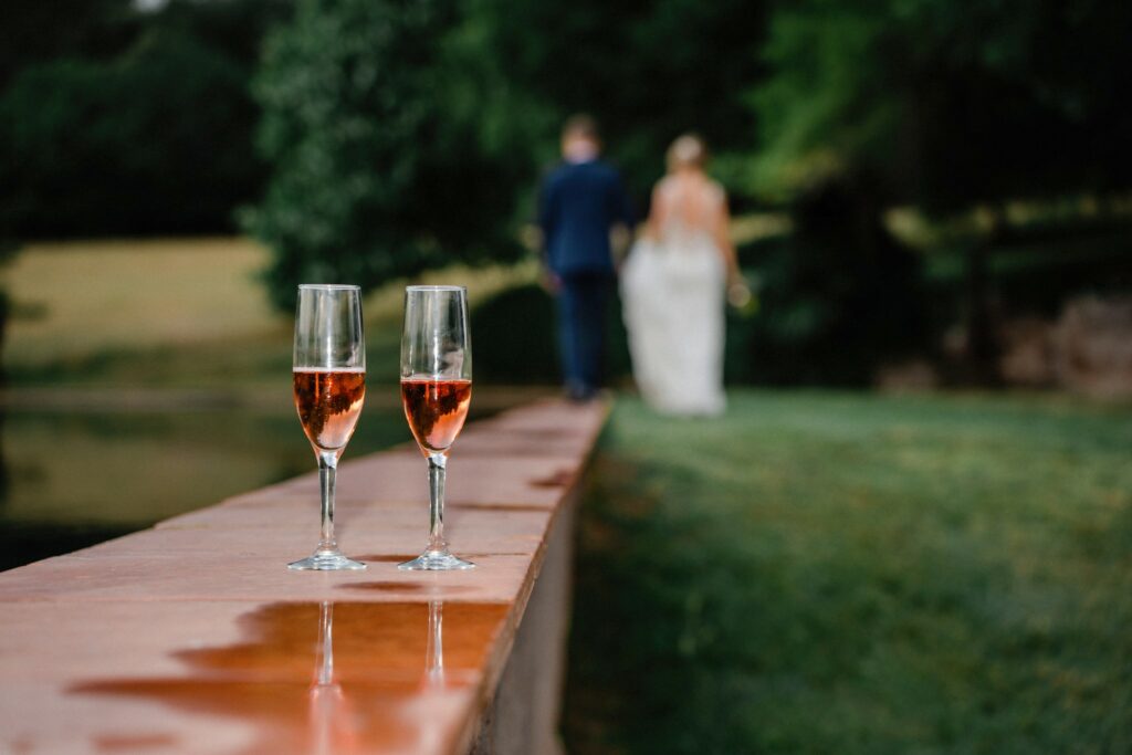 dos copas de cava y de fondo los novios caminando