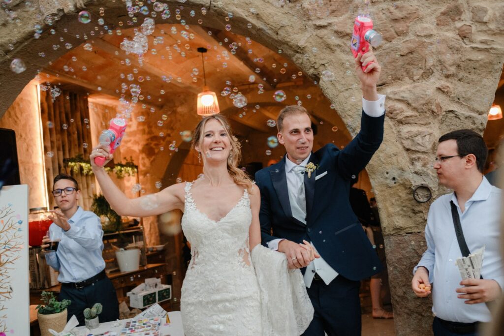 los novios entrando al aperitivo con pistolas de burbujas