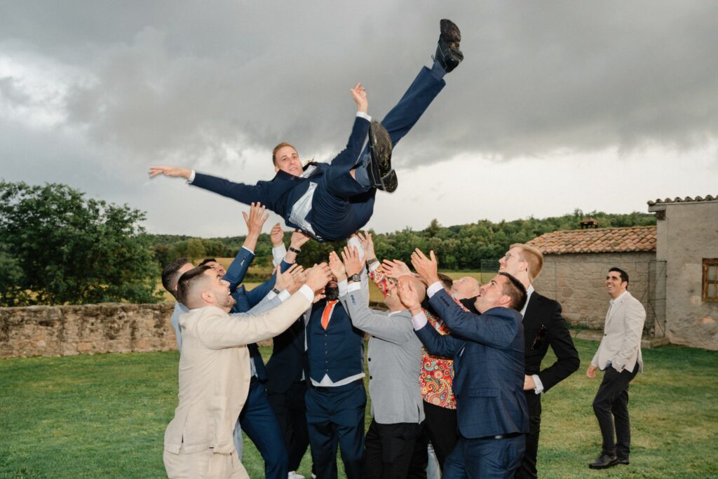 el novio está siendo manteado por los amigos