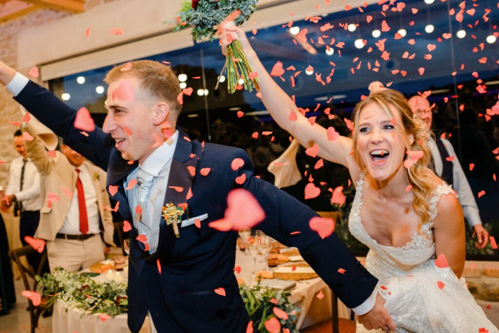novios saltando rodeados de pétalos